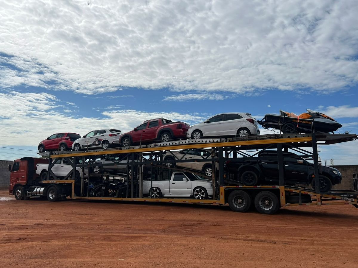 Cegonha da Goianão Transportes carregada com caminhonetes, carros, motos e um jet-ski