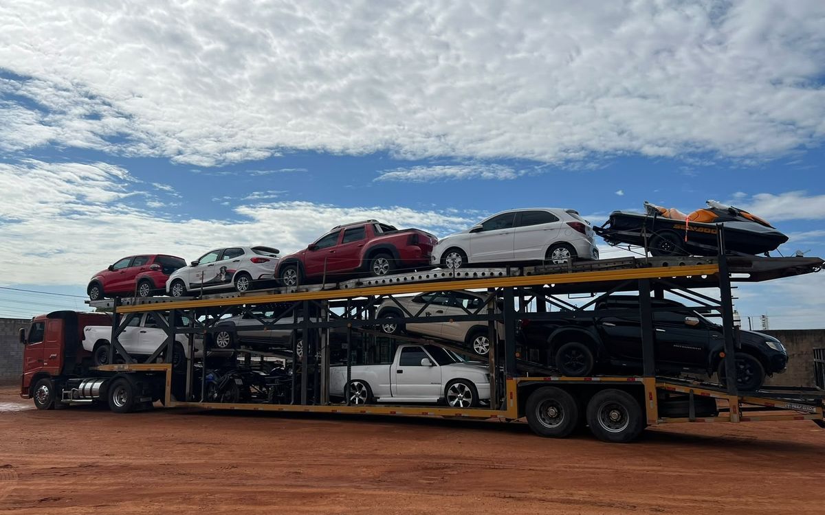 Cegonha da Goianão Transportes carregada com caminhonetes, carros, motos e um jet-ski