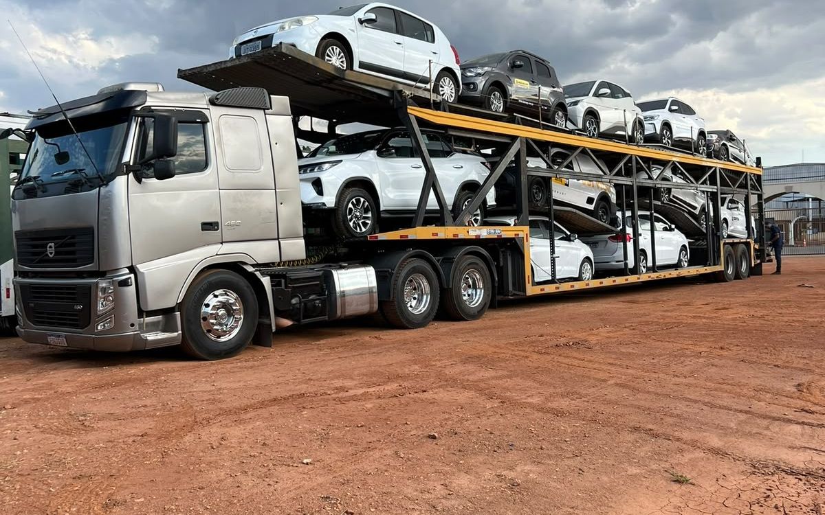 Cegonha da Goianão Transportes carregada com carros e SUVs brancos para concessionária