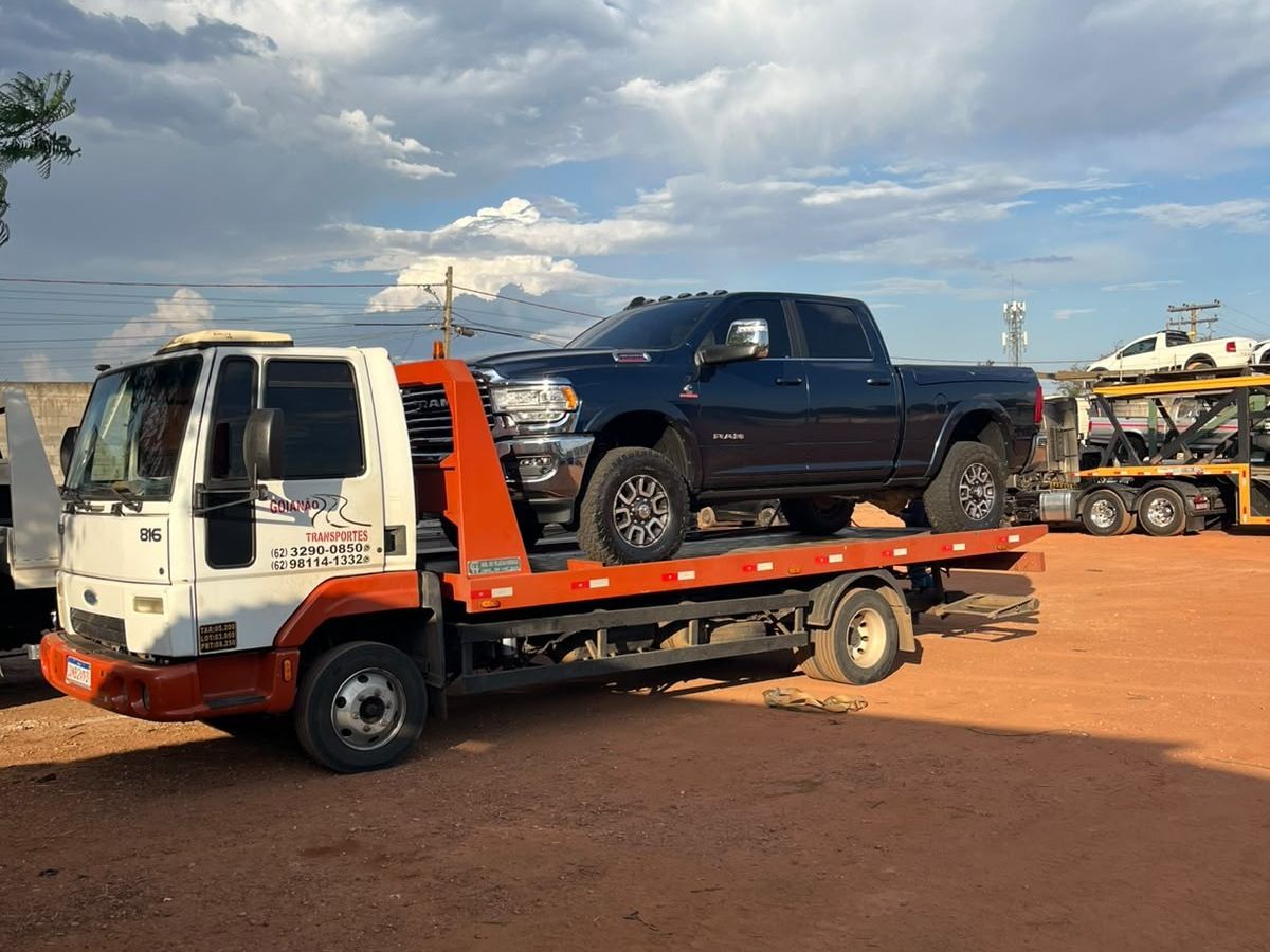 Guincho plataforma da Goianão Transportes levando uma caminhonete Ram no pátio